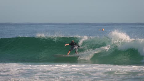 Surfer-on-on-a-small-wave-on-a-calm-sunny-day-at-Snapper-Rocks,-Gold-Coast