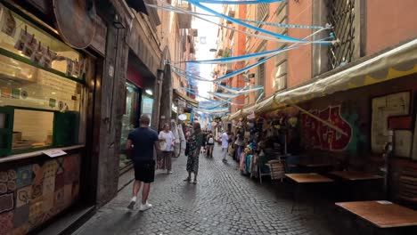 POV-Aufnahme-Eines-Spaziergangs-Durch-Eine-Schmale-Straße-Im-Stadtzentrum-Mit-Geschäften-Und-Cafés-Von-Neapel-In-Italien