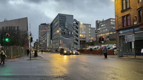 Dusk-cityscape-with-traffic-and-pedestrians-at-a-Glasgow-intersection,-time-lapse