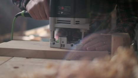Carpenter-sawing-wood-in-moody-workshop