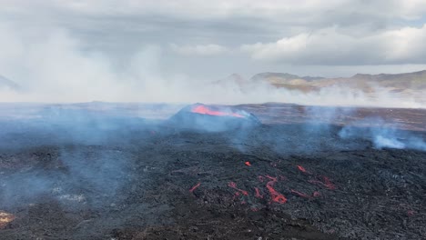 Active-volcano-crater-with-smoke-covered-magma-field,-Iceland