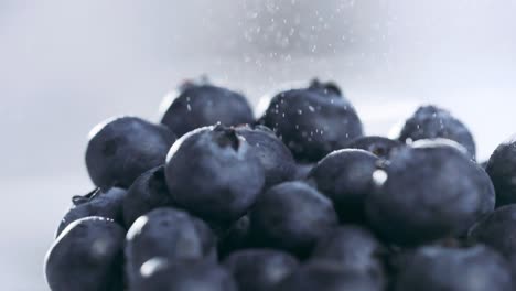 Extreme-close-up-of-Water-Particles-pouring-on-top-of-Blueberries-pile-in-Slow-motion