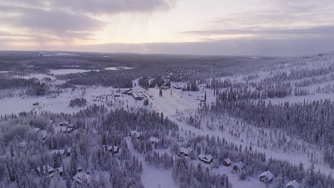 Aerial-view-circling-toward-the-parking-lot-under-the-slopes-of-Iso-Syote,-winter-in-Finland