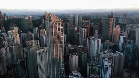 Drone-tilting-away-from-skyscrapers-in-the-City-of-Makati,-Manila,-Philippines