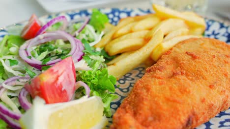 Delicious-fish-and-chips-with-fresh-salads-in-restaurant,-close-up