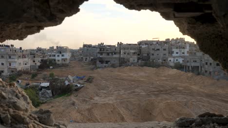 Reverse-reveal-of-a-hole-in-the-wall-while-looking-towards-a-destroyed-Gaza-city-block