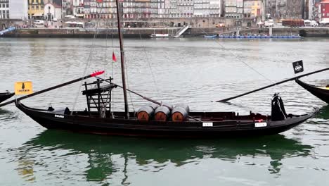Traditionelles-Sandeman-Rabelo-Boot,-Das-Sich-Mit-Der-Flut-Des-Flusses-Douro-Wiegt-Und-Sechs-Fässer-Portwein-Trägt