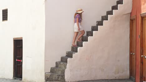 Attractive-woman-walking-up-stairs-in-Puerto-de-la-Cruz,-side-view