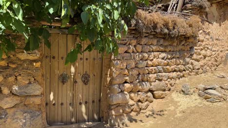 wonderful-scenic-shot-from-old-traditional-house-wooden-door-stone-wall-tree-shade-in-rural-village-countryside-in-Iran-Esfahan-remote-outdoor-adventure-travel-to-visit-local-people-life-doorknob