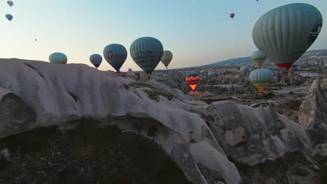 Hot-Air-Balloons-Floating-Above-Fairy-Chimneys-And-White-Hills-At-Sunrise-In-Cappadocia,-Turkey