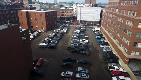 Aerial-view-of-rooftop-parking-lot-with-downtown-office-building-in-the-background