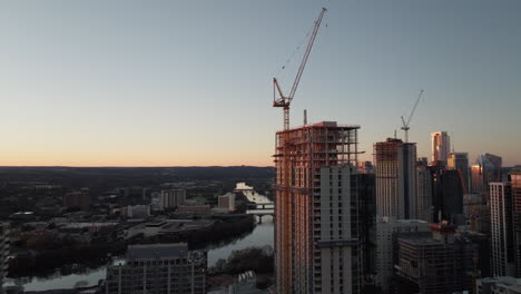 Beautiful-aerial-of-downtown-Austin-Texas-buildings-with-Lady-Bird-lake-river-at-sunset