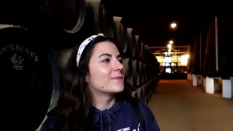 Female-tourist-looking-to-Cockburns-Wine-Cellar-with-oak-barrels-in-background