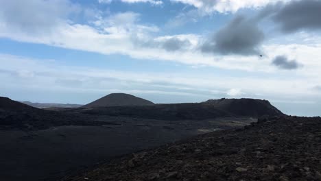 Helicopter-flying-over-volcano-crater-and-lava-field-in-Iceland