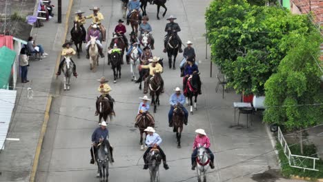Mexican-People-Riding-Horses-On-Street-At-Mariachi-Festival-Inaugural-Parade-In-Tecalitlan,-Mexico