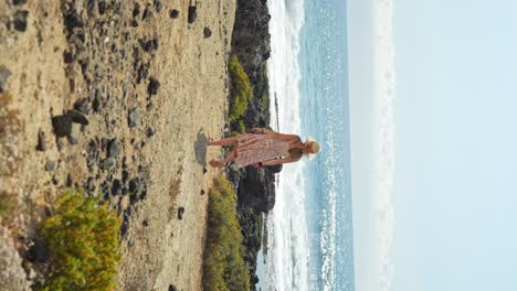 Mujer-Aventurera-Caminando-Hacia-El-Océano-En-Tenerife,-Vista-Vertical-Posterior