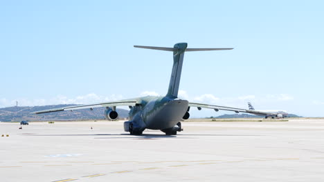 Handheld-shot-of-military-transport-aircraft-taxiing-at-Athens-airport-on-sunny-day