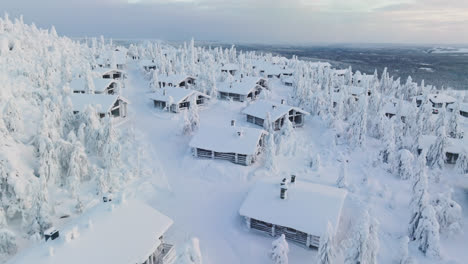 Aerial-view-over-snowy-cottage-on-top-of-a-fell-mountain,-winter-in-Lapland