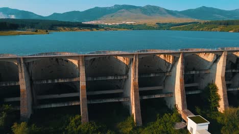 Drone-shot-of-a-lake-blocked-by-a-long-dam
