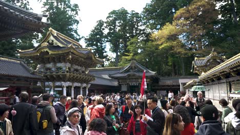 Grupo-Turístico-Reunido-Alrededor-Del-Líder-Del-Recorrido-En-El-Patio-De-Nikko-Toshogu,-Nikko