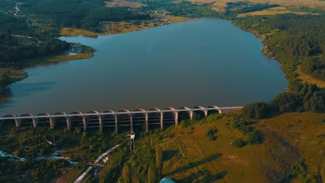 Drone-shot-of-a-lake-blocked-by-a-long-dam