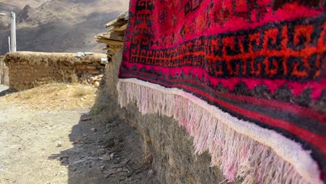 local-people-wash-red-handmade-wool-silk-carpet-the-persian-art-of-weaving-rug-in-Iran-nomad-rural-life-village-town-countryside-stone-house-mountain-landscape-wonderful-peaceful-life-in-remote