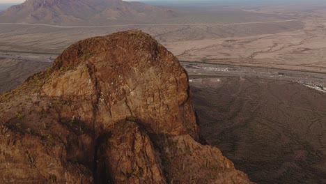 Aerial-Drone-Footage-Over-Sunlit-Mountain-Formations-in-Sonoran-Desert-in-Tucson-Arizona,-Sunset-on-Picacho-Peak