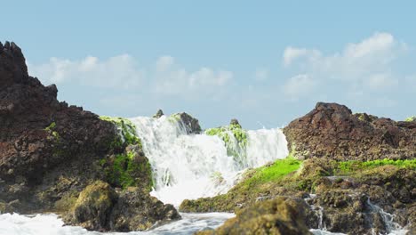Atlantic-ocean-flows-over-mossy-rocks-of-Tenerife,-low-angle-view