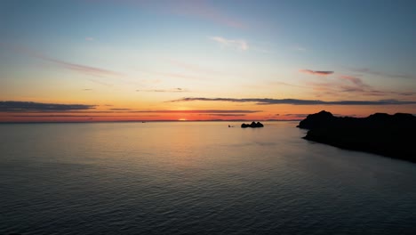 Isländische-Küstenlandschaft-Mit-Friedlicher-Golden-orangefarbener-Sonnenuntergangs-Skyline