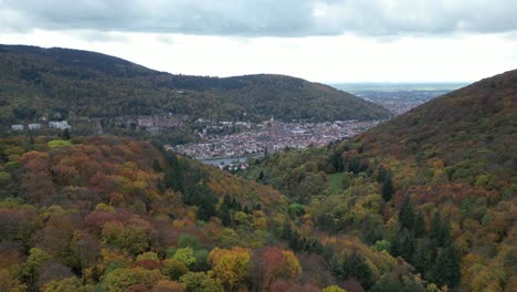 Pull-away-drone-shot-of-Heidelberg,-shot-from-above-autumn-forest