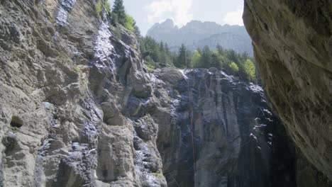 Climbing-Ropes-On-Cliffiside-of-Open-Cave-|-Grindelwald-Switzerland-Cave-in-Glacier-Canyon,-Europe,-4k