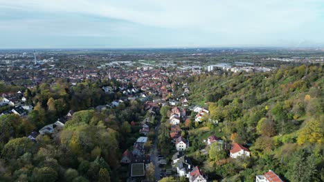 Medium-angle-Drone-shot-of-Handschuhsheim,-flying-above-town-push-in-shot,-flying-down-hill-towards-town