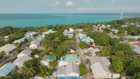 An-Aerial-Shot-Of-A-Village-Near-The-Coast-On-A-tropical-Landscape-And-A-Tree-Line