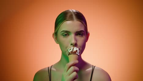 Nordic-blonde-woman-sucks-an-ice-cream-cone-suggestively-looking-at-the-camera,-close-up-portrait-shot