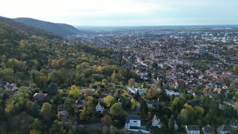 Ascending-Drone-shot-of-Heidelberg,-drone-flying-up-hill-looking-towards-Heidelberg-city-centre