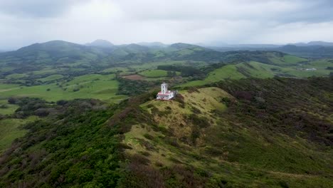 Luftaufnahme-Des-Leuchtturms-Von-Roca-Partida-Auf-Einem-Wunderschönen-Grünen-Hügel