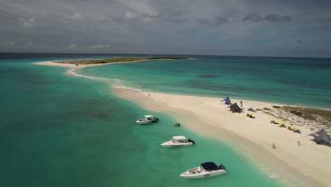 Los-roques-archipelago-in-venezuela-with-clear-turquoise-waters,-white-sandy-beach,-and-moored-boats,-aerial-view