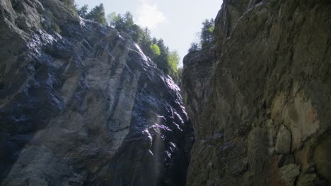 Agua-Brumosa-Que-Fluye-Desde-El-Acantilado-De-La-Cueva-De-La-Montaña-|-Cueva-De-Grindelwald-Suiza-En-El-Cañón-Del-Glaciar,-Europa,-4k