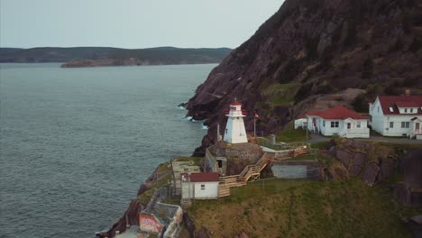Fort-Amherst-lighthouse-on-rocky-seaside-cliff-with-white-buildings-and-red-roofs