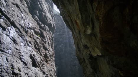 Mirando-Hacia-Arriba-Desde-La-Parte-Oscura-De-La-Cueva-Hacia-Las-Brillantes-Rocas-De-La-Ladera-De-La-Montaña-|-Cueva-De-Grindelwald-Suiza-En-El-Cañón-Del-Glaciar,-Europa,-4k