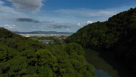 Aerial-view-around-forest,-revealing-the-cityscape-of-Kyoto,-summer-in-Japan