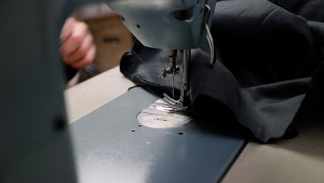 Sewing-final-part-of-a-garment-with-sewing-machine-and-cutting-the-thread