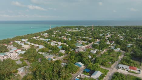 Eine-Luftaufnahme-Eines-Dorfes-In-Küstennähe-Mit-Gebäuden-Und-Tropischen-Bäumen