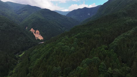 Aerial-ascending-shot-of-the-Jigokudani-Valley,-in-the-Joshinetsu-National-Park,-summer-in-Japan