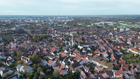High-angle-drone-shot-of-Handschuhsheim-and-Heidelberg,-flying-above-town-orbiting-around-Friedenskirche-church