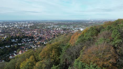 Aerial-shott-of-Handschuhsheim,-flying-above-forest,-panning-in-towards-town-and-Friedenskirche-church