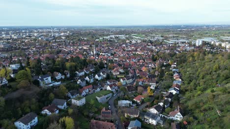Medium-angle-Drone-shot-of-Handschuhsheim,-flying-above-town-push-in-shot,-flying-down-hill-towards-town-and-Friedenskirche-church