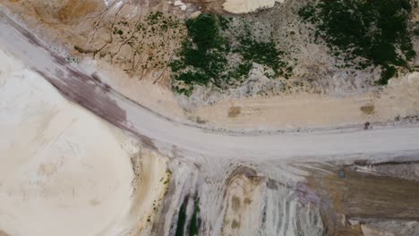 Gravel-road-in-sand-quarry,-aerial-top-down-view