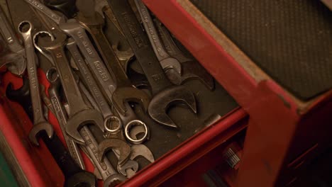 Kaukasische-Männliche-Hand-öffnet-Die-Schublade-Eines-Roten-Werkzeugschranks,-Gefüllt-Mit-Verschiedenen-Schraubenschlüsseln