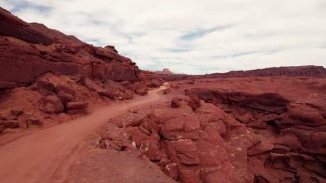 Drone-shot-flying-up-an-off-road-trail-outside-of-Moab,-Utah